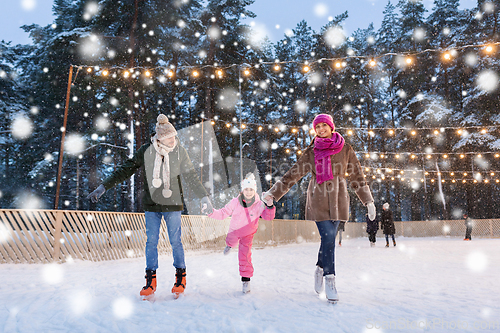 Image of happy family at outdoor skating rink in winter