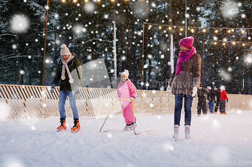 Image of happy family at outdoor skating rink in winter