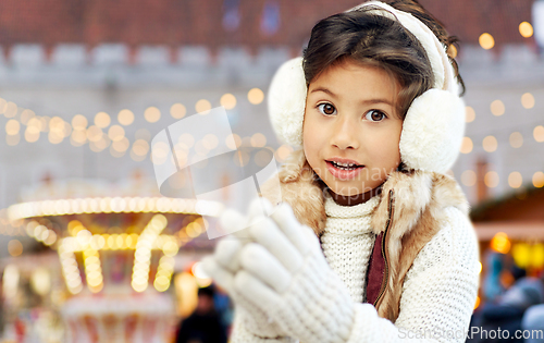 Image of little girl in earmuffs at christmas market