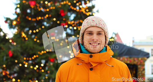 Image of happy young man over christmas market background