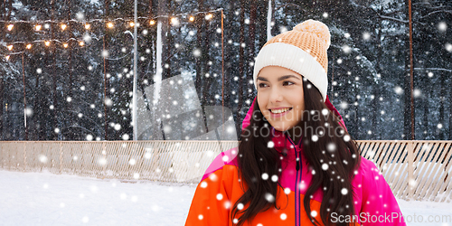 Image of happy teenage girl over ice skating rink in winter