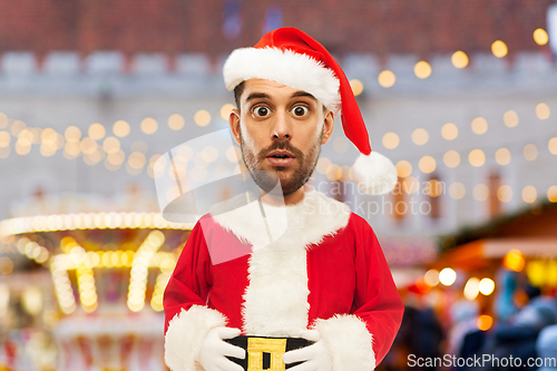 Image of surprised man in santa costume at christmas market