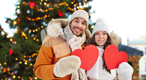 Image of happy couple with red hearts at christmas market