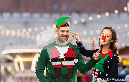 Image of couple in sweaters with christmas party props