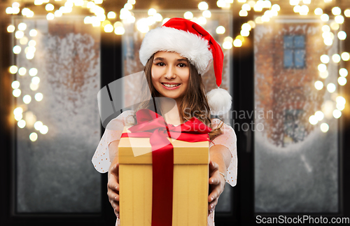 Image of teenage girl in santa hat with christmas gift