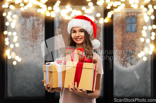 Image of teenage girl in santa hat with christmas gift