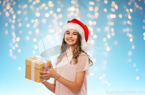 Image of teenage girl in santa hat with christmas gift