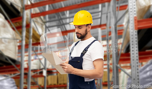 Image of male loader or worker with clipboard at warehouse