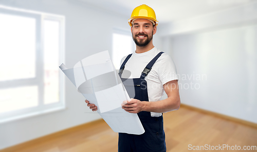 Image of male worker or builder in helmet with blueprint