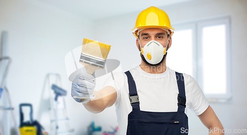 Image of worker or builder in respirator with brush