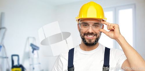 Image of happy male worker or builder in helmet and overall