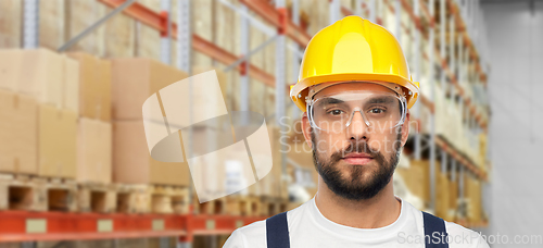 Image of male worker or loader in helmet at warehouse