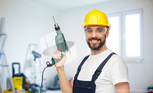 Image of happy male worker or builder in helmet with drill