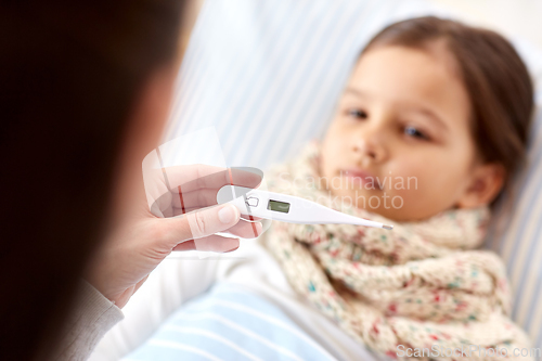 Image of mother measuring temperature of sick daughter