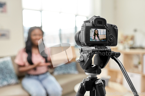 Image of female video blogger with camera and box at home