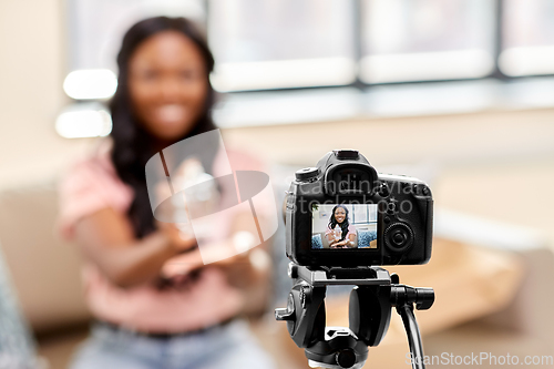 Image of female beauty blogger with camera and perfume