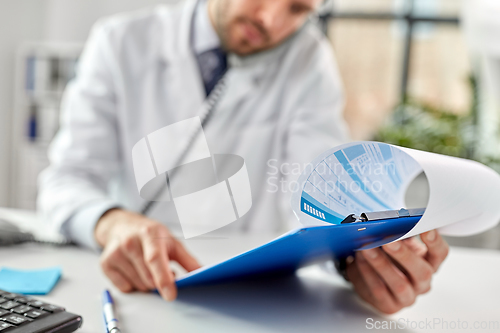 Image of male doctor calling on desk phone at hospital