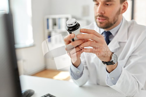 Image of smiling male doctor with medicine at hospital