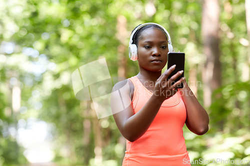 Image of african american woman with headphones and phone