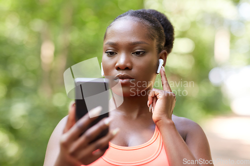 Image of african american woman with earphones and phone