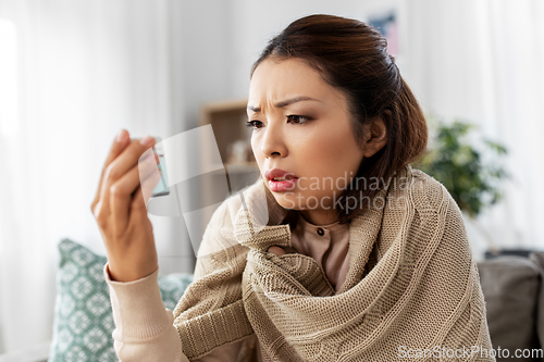 Image of sick asian woman with medicine at home