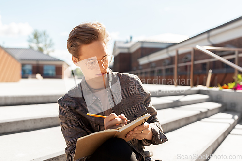 Image of young man with notebook or sketchbook in city