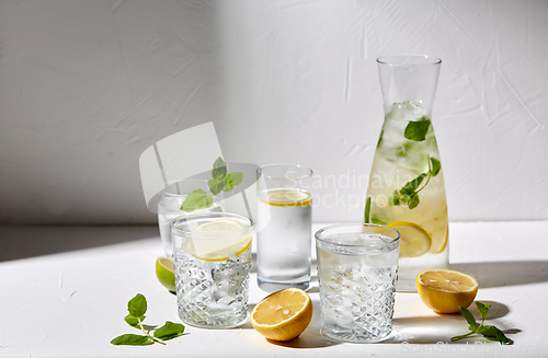 Image of glasses with lemon water and peppermint on table