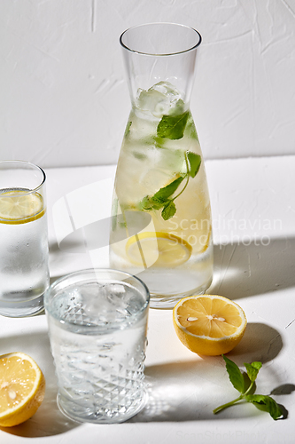 Image of glasses with lemon water and peppermint on table