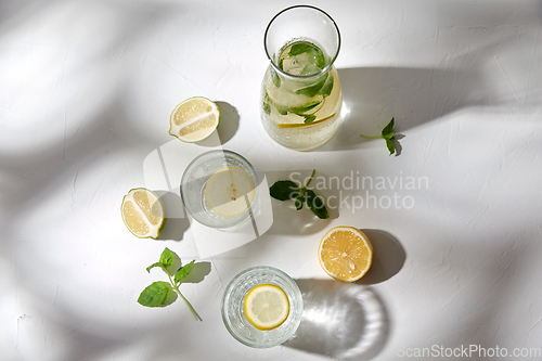 Image of glasses with lemon water and peppermint on table