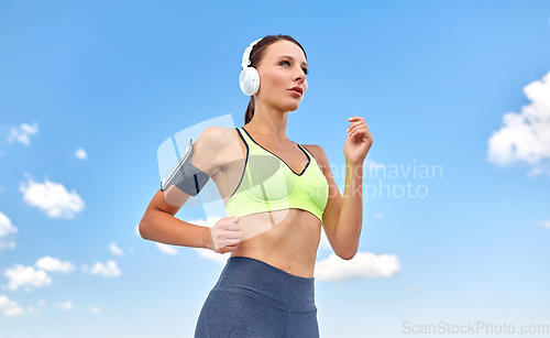 Image of woman with headphones and smartphone running