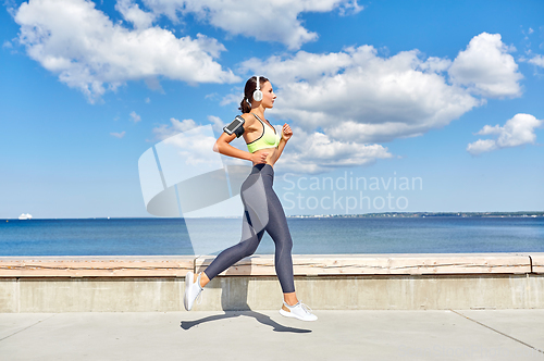 Image of woman with headphones and smartphone running