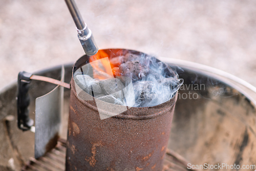 Image of Coal heater on a grill with a gas flame