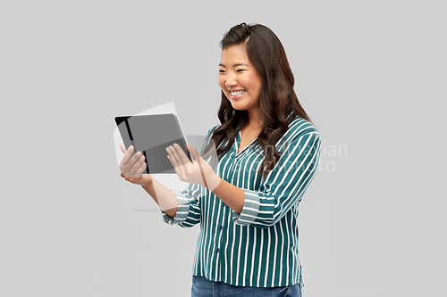 Image of happy asian woman using tablet computer
