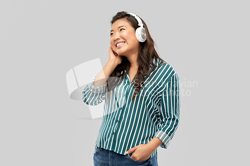 Image of asian woman in headphones listening to music