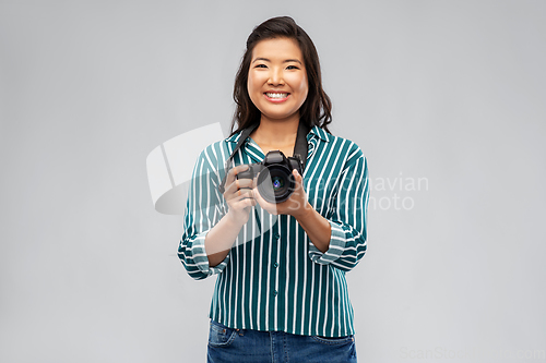 Image of asian female photographer with digital camera