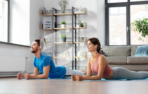 Image of happy couple exercising at home