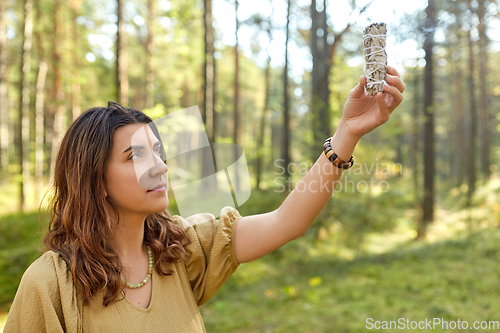 Image of woman or witch performing magic ritual in forest