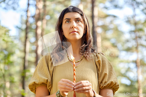 Image of woman or witch performing magic ritual in forest
