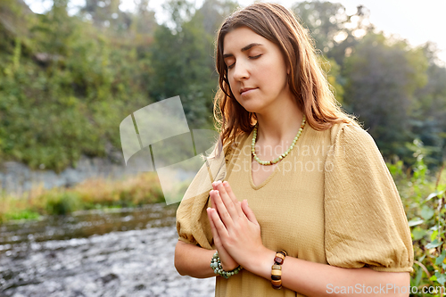 Image of woman or witch performing magic ritual on river