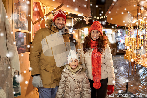 Image of happy family at christmas market in city