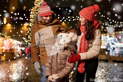 Image of happy family at christmas market in city