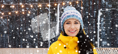 Image of happy young woman over ice skating rink in winter