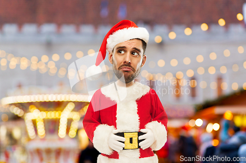 Image of sad man in santa claus costume at christmas market