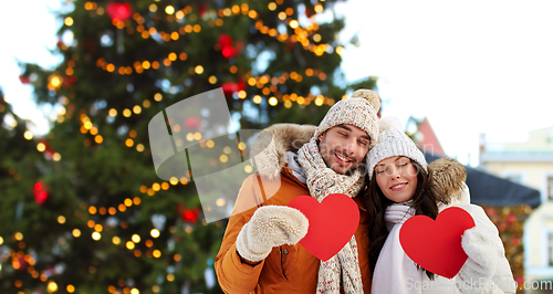 Image of happy couple with red hearts at christmas market