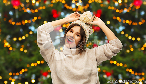 Image of happy woman in hat and sweater on christmas