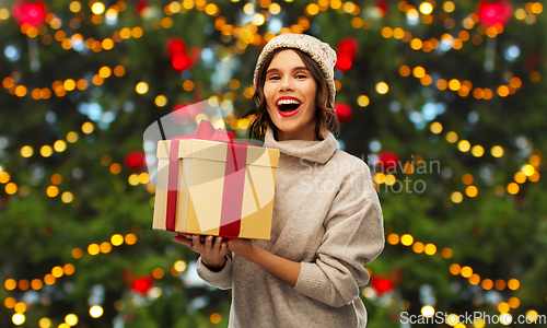 Image of happy young woman holding christmas gift