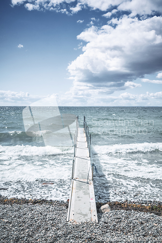 Image of Small pier at a cold sea with waves coming in