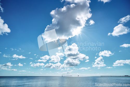 Image of Seascape wit the sun hiding behind a cloud