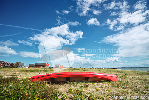 Image of Red kayak on the shore in the summer