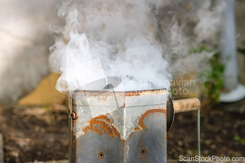 Image of Coal heater in rusty metal with smoke